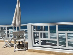 A seaside terrace with white railings, a white umbrella, and a chair. - Oceanfront villa near Agadir, private pool! Sidi Ifni (Sidi Ifni)