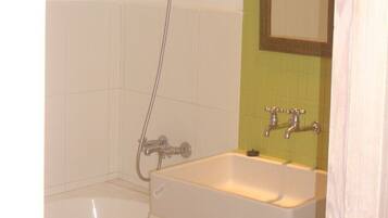 Une salle de bain avec une baignoire, un lavabo et une douche.