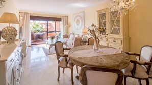 Un vaste espace dédié à la salle à manger, avec une table ronde en bois, des chaises rembourrées et un lustre.