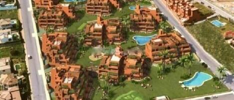 A resort with multiple buildings, swimming pools, and well-maintained lawns.