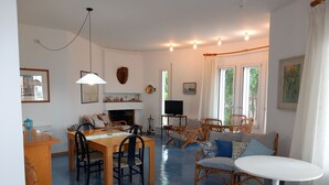 Un salón amplio con comedor, ventanas grandes y chimenea.