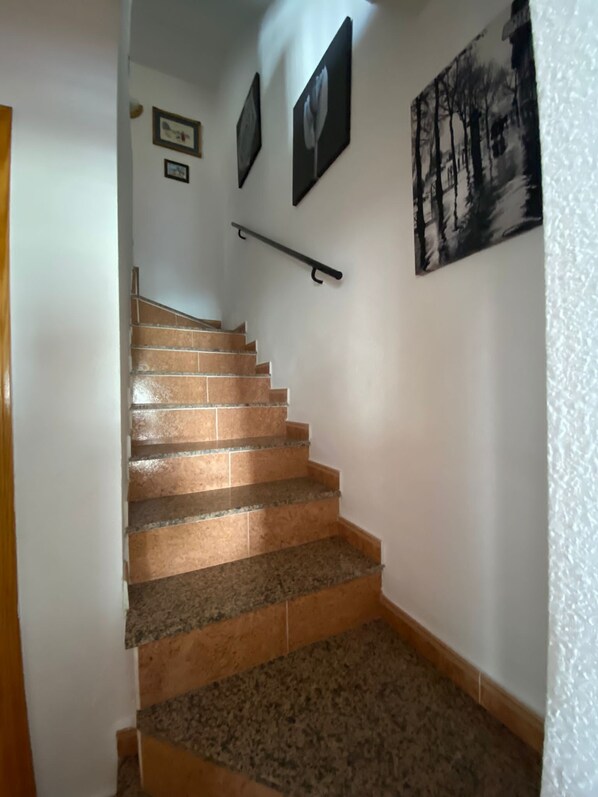 A staircase with a handrail, leading to an upper floor.
