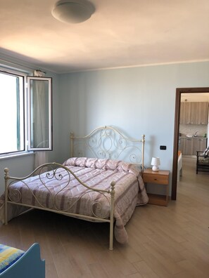 A bedroom with a bed, a bedside table, a lamp, and a window. - Il Terrazzo su Pizzo - panoramic apartment with sea view (Pizzo)