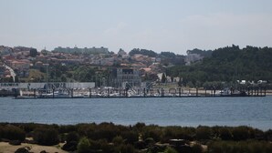 A marina with boats docked, a bridge, and a hillside town in the background. - Hipster´s dream by the river (Porto)