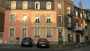 Une rangée d’immeubles à étages multiples, de style architectural uniforme, dotés de balcons et de grandes fenêtres.