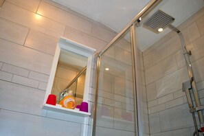 Chuveiro, secador de cabelo, toalhas de banho, papel higiênico
