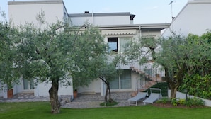 Ein modernes Wohngebäude mit einer Steintreppe, die zu einem Balkon führt.