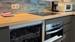 Una cocina equipada con lavavajillas, horno, microondas y cafetera.
