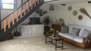 A spacious living room with a staircase, a sofa, a coffee table, and a television. - Casa Nerelie S big garden for playing, wi-fi free!!I - IT091063C2000P2044 (Orosei)