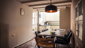 A dining area with a table, chairs, and a pendant light.