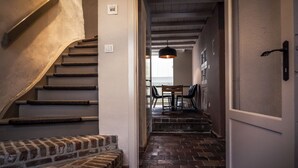 A staircase with a brick wall and a wooden bench at the bottom.