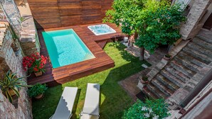 A rooftop pool with wooden deck, two lounge chairs, and potted plants. - Villa Elisa Historical residence Welness (Spello)