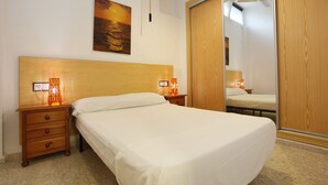 Une chambre à coucher avec un lit, une tête de lit en bois, des tables de chevet, une commode, un miroir et un tableau accroché au mur.