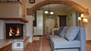 Una sala acogedora con chimenea, un sofá y una zona de comedor.
