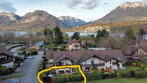 A residential area with houses, a winding road, and mountains in the background. - T3. 2 Bed Apart Private Garden, 200m to beach. super fast wifi. cheap bikes (Saint-Jorioz)