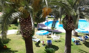 A poolside area with palm trees, lounge chairs, and umbrellas. - relax in the green near the sea and from the center of Forio (Forio)
