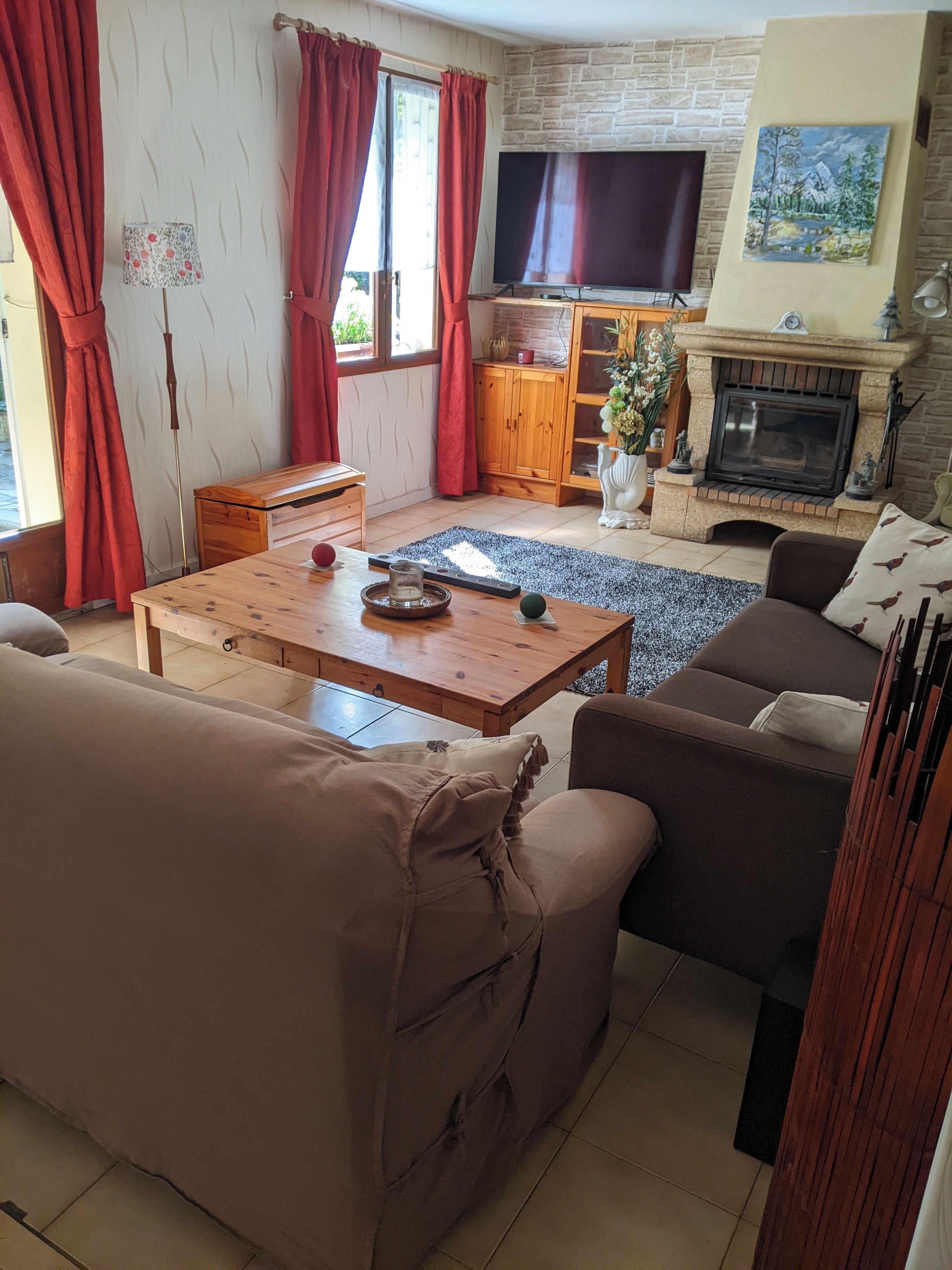 A cozy living room with a fireplace, a television, and a comfortable seating area.