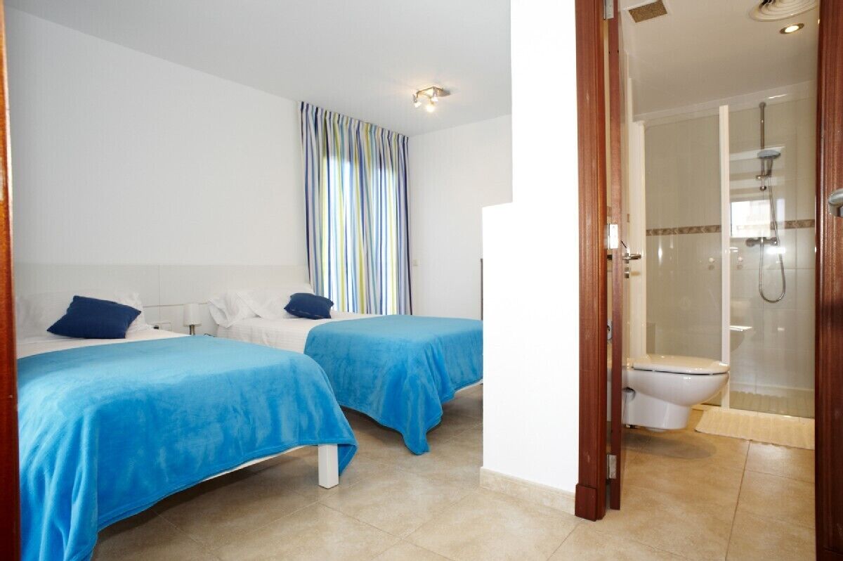 Una habitación de hotel con dos camas, ducha y baño.