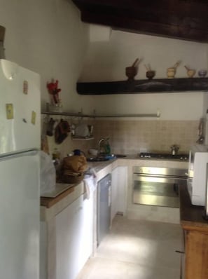 Cozinha compacta com geladeira, fogão e pia.