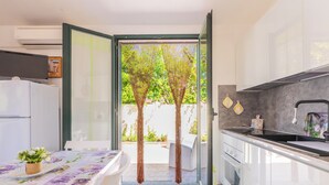 Una cocina moderna con un ventanal amplio, un comedor con mesa y vistas al jardín.