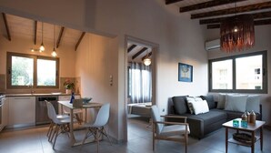 A modern living space with a kitchen, dining area, and seating area. - Rea's Sea House with private pool (10m x 4m) (Galatas)