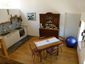 Una cocina compacta con una mesa de comedor, sillas y una pelota de ejercicios azul.