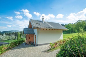 A small, single-story house with a tiled roof, a chimney, and a paved driveway. - Rustic-modern Ferienalm in the middle of the Black Forest (Kirchzarten)