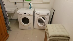 Une buanderie équipée de deux machines à laver, d’un sèche-linge et d’une pile de serviettes pliées.