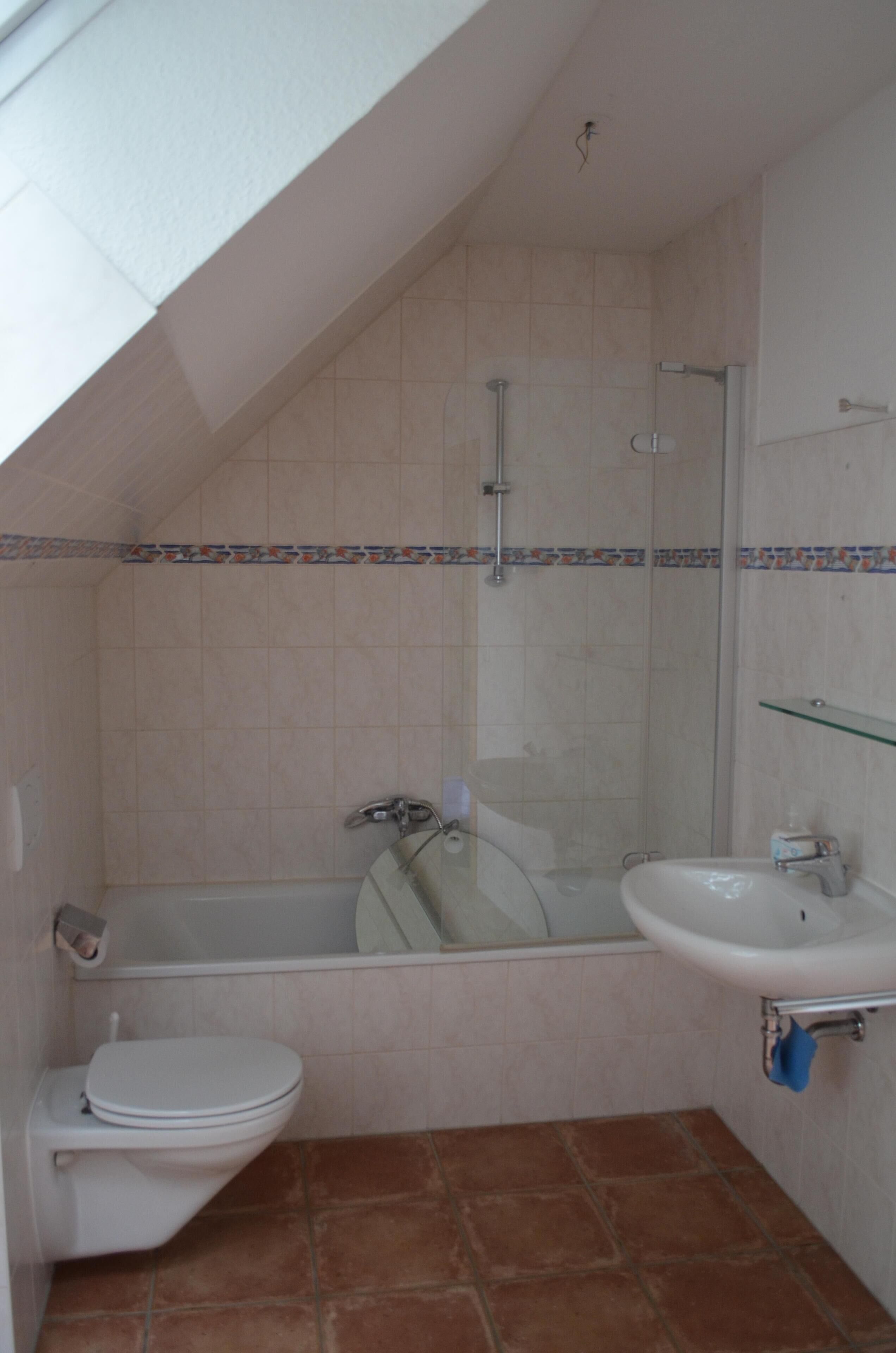 Een badkamer met een bad, toilet en wastafel.
