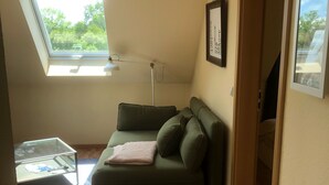 A cozy room with a green sofa, a glass coffee table, and a skylight. - Pferdehof Muhlitz on Rügen, an idyll for individualists (Samtens)