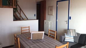 Un espace repas comprenant une table, des chaises, un radiateur et un canapé.