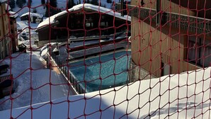 A snow-covered landscape with a pool area, wooden buildings, and a ski lift in the background. - Calysto, 3 *, Heart of Belle-Plagne, on the slopes (La Plagne Tarentaise)