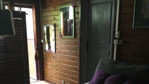 A room with a bed, a door, and a mirror on the wall. - The AZAE chalet, from relaxation to escape, in a green setting (Saint-Louis de la Reunion)
