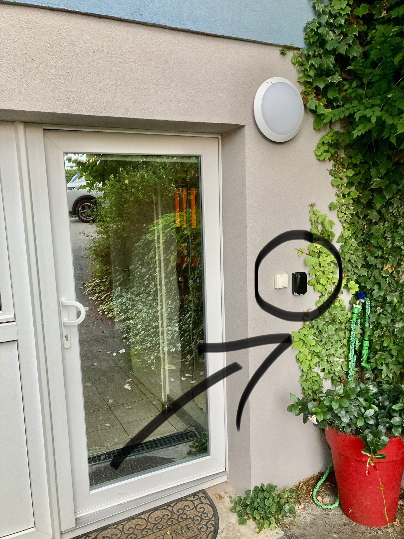 Una puerta con un panel de vidrio, un picaporte blanco y un felpudo.