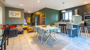 A modern kitchen with a central island, bar stools, and a dining table with chairs. - IDEALLY LOCATED GD APARTMENT, PARKING & PRIVATE TERRACE, JACCUZI, QUIET, DOMLOC (Carcassonne)