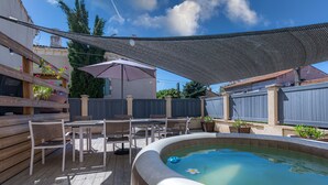 A backyard with a hot tub, wooden deck, outdoor furniture, and a shaded area. - IDEALLY LOCATED GD APARTMENT, PARKING & PRIVATE TERRACE, JACCUZI, QUIET, DOMLOC (Carcassonne)