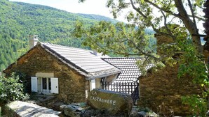 A rustic stone building with a tiled roof, a white door, and a sign reading "LA CASTAGNERE." - Eco-responsible cottage CASTAGNERE 4* EN CEVENNES: air conditioning, pets welcome (Aujac)