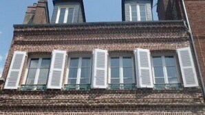 A brick building with multiple windows and shutters. - French Charm.  Charming 40-square-meter apartment.⭐️⭐️⭐️ (Honfleur)