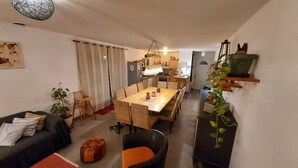Un ambiente compatto con zona pranzo, divano, un tavolino e televisore su un ripiano.