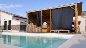 Una struttura in legno con un'amaca e una piscina.