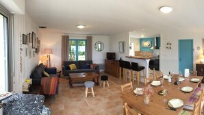 A spacious living area with a sofa, coffee table, and dining table set for a meal. - Beautiful VILLA 100m2 with view and direct access to the sea, 3 bedrooms, bathroom, living room, in enclosed park (Fouras)