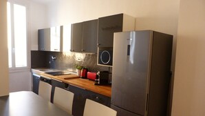 A compact kitchen with a refrigerator, a sink, and a countertop.