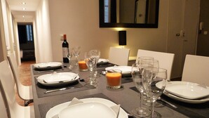 A dining table set for a meal with plates, cutlery, and wine glasses.