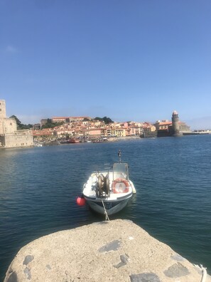 Ein Boot liegt im Hafen vor einer historischen Stadt.