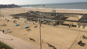 A beachside building with a cafe, outdoor seating, and a lifeguard tower. - Trouville-sur-mer feet in the water (Trouville-Sur-Mer)