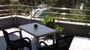 A balcony with a table and chairs, overlooking a marina and a mountainous landscape. - Independent apartment in villa, in the pines overlooking the sea. (Ensuès-La-Redonne)