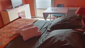 Habitació d'hotel amb llit, escriptori, cadira i taula.