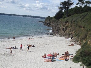 A beach with people sunbathing and swimming, a rocky coastline, and a view of the sea. - Charming house, 3***, 400m from the beach, GR34 and thalasso baths (Concarneau)