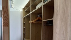 Een inloopkast met houten planken, een kledingroede en een ladekast met een patroon.