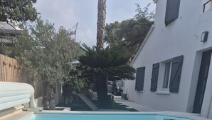 Een rechthoekig zwembad met helderblauw water, omgeven door een betegeld terras.